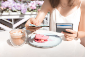 A woman pays for Breakfast in a cafe. The concept of cash and VAT