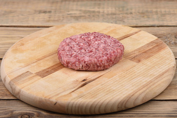 Raw pink beef cutlet on a cutting board..