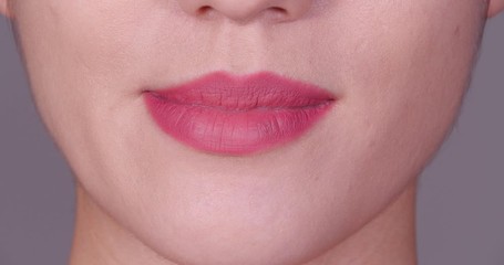 Beautiful young woman putting chewing gum in mouth, closeup