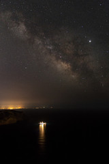 Fototapeta na wymiar Milky way and stars over a harboured marine research ship near Es Vedra in Ibiza