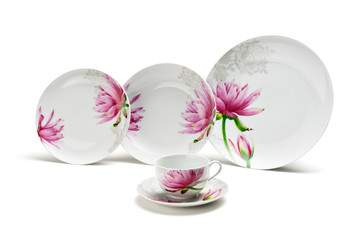 A set of dishes with cup and saucer decorated with a floral pattern, isolated on a white background.