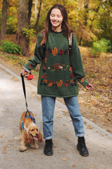 woman with american cocker spaniel walks at autumn park