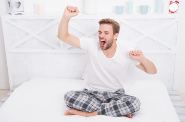 man relax in bed. perfect morning. yawn and stretch in the morning. feeling cosy and comfortable. Menswear pajamas. Pajamas for home relax. male feeling sleepy. yawning man sit in pajama