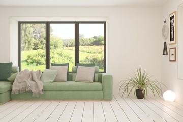 Fototapeta premium Stylish room in white color with sofa and summer landscape in window. Scandinavian interior design. 3D illustration