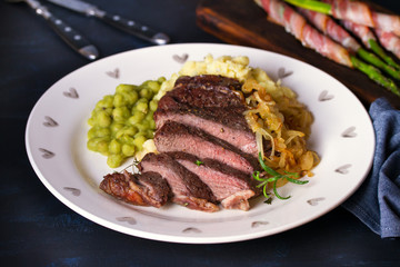 Grilled fillet beef steak with mashed potato, peas and fried onion