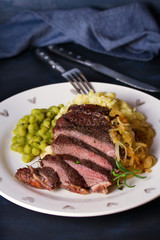 Grilled fillet beef steak with mashed potato, peas and fried onion