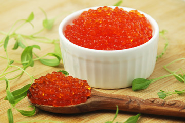 A small ceramic bowl with red caviar