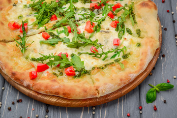 Traditional italian pizza with arugula on wooden background