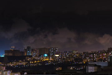 Evening shot of a city on hill buildings.Top aerial panoramic view. Construction cranes on new residential areas