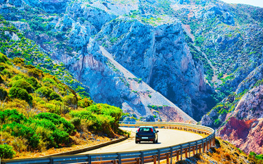 Car on the road at Buggerru in Sardinia Island in Italy summer. Transport driving on the highway of...