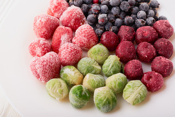 Frozen food in a plate - strawberries with cherries and brussels sprouts with shadberry