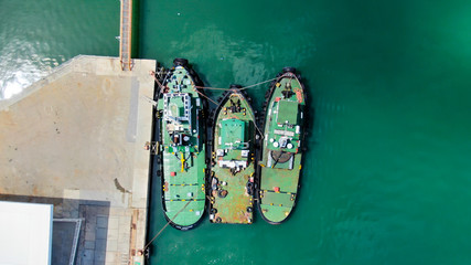 aerial view of three boats tugs alongside to each other, awaiting for towing operations in the harbor.