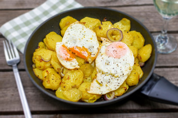 Hearty fried potatoes with fried egg. Arranged in the pan