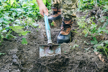 Man is digging ground with a shovel. Tourist in the nature. Making stairs outdoors.