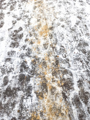 Winter road with sand in the snow. Foot prints.