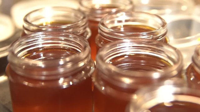 THC infused coconut oil and Cayenne Pepper ointment in glass jars. Gimbal Pulling back