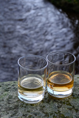 Scotch single malts or blended whisky spirits in glasses with water of river Spey on background, Scotland