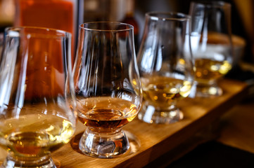 Scotch whisky, tasting glasses with variety of single malts or blended whiskey spirits on distillery tour in Scotland