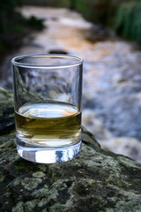 Scotch single malts or blended whisky spirits in glasses with water of river Spey on background, Scotland
