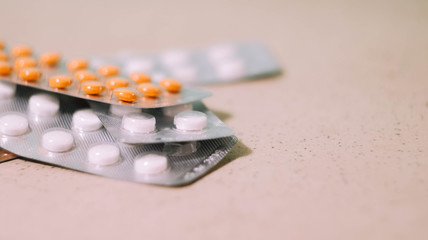 White and orange tablets in blisters. Health care wallpaper. Pharmaceutical company. Sickness...