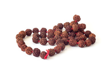 rosary of red brown rudraksha seeds close-up isolated on a white background