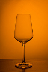 wine glass in the dark on a yellow orange background