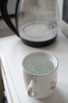 Floating Settled Limescale On The Water Surface In A Cup During Coffe Preparation In The Kitchen Due To Hard Water