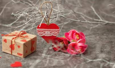 Holiday background for Valentine's Day on a gray cement background with white painted branches and a sheet of paper for text