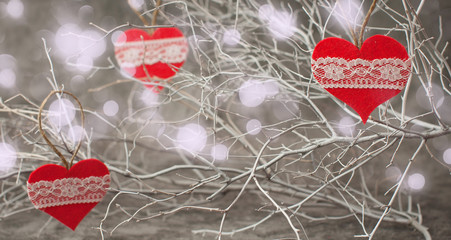 Holiday background for Valentine's Day on a gray cement background with white painted branches and a sheet of paper for text