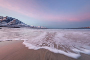 Amazing sunrise with amazing magenta color over sand beach. Tromso, Norway . Polar night. long shutter speed