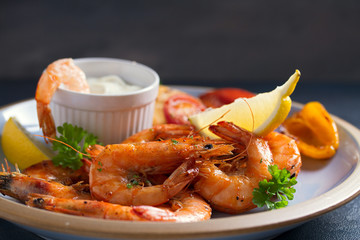 Shrimps or prawns with vegetables, garlic and sauce on plate 