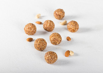 Energy balls made of dried apricots, dates, cashews and almonds on a linen napkin on a light background