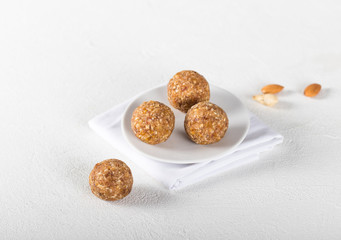 Energy balls made of dried apricots, dates, cashews and almonds on a linen napkin on a light background