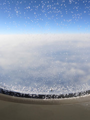 Frost on the airplane window. Travel and relax concept. Blue and white background. Calm mood