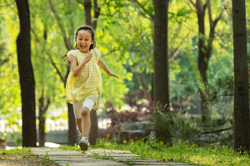 The little girl is running in the park