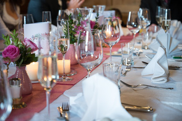 Festlich gedeckte Tafel mit Gläsern, Servietten und Blumen
