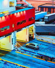 Car loading at Cruise ship at Mediterranean Sea at port of Cagliari in Sardinia Island, Italy summer. Truck trailer driving on motorway on holidays at highway. Scooter with motorcyclists. Mixed media.