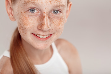 Inclusive Beauty. Girl with freckles standing isolated on grey smiling happy top view close-up