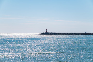 Clear sky over the sea with a breakwater and a lighthouse