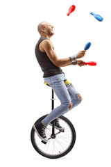 Bald man juggling and riding a unicycle © Ljupco Smokovski