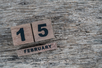 cube calendar for february on wooden background with copy space