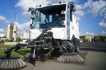 A special car - a vacuum cleaner and a sweeper for cleaning city streets. Landscaping and urban...