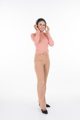 Cheerful Asian teenager wearing turtleneck and pants using wireless headphones enjoying listening to music studio portrait shot isolated on white background. Easy to cut out. Portrait orientation.