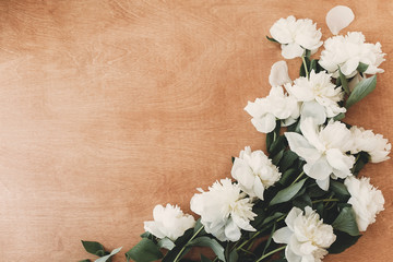 Stylish white peony flat lay on rustic wooden table with space for text. Greeting card mockup. White peonies rural still life. Hello spring image. Happy Mothers day. International Womens days