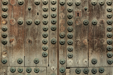 Rusty old knocker on weathered wooden door Greenish deteriorated door detail