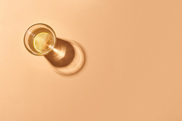 Glass of water with lemon isolated on orange .Orange background. Top view.