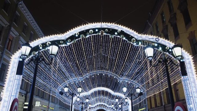 View from the bottom on the beautiful Christmas decorations on the street, white garland of lights and street lights. Concept. Christmas mood