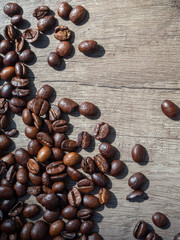 Black coffee in grains on the surface of a wooden table, with place for text.