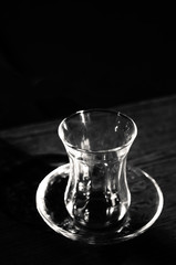 Tulip tea glass. Traditional bardak glass of hot Turkish tea on black background top view. Black and white. Asian or Arabic tradition of drinking black tea