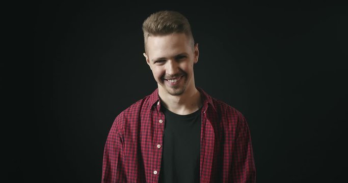 Happy smiling man in casual clothing nodding yes isolated on black background, success, accepting proposition